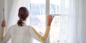 Frau schaut aus dem Fenster Frau schaut aus dem Fenster