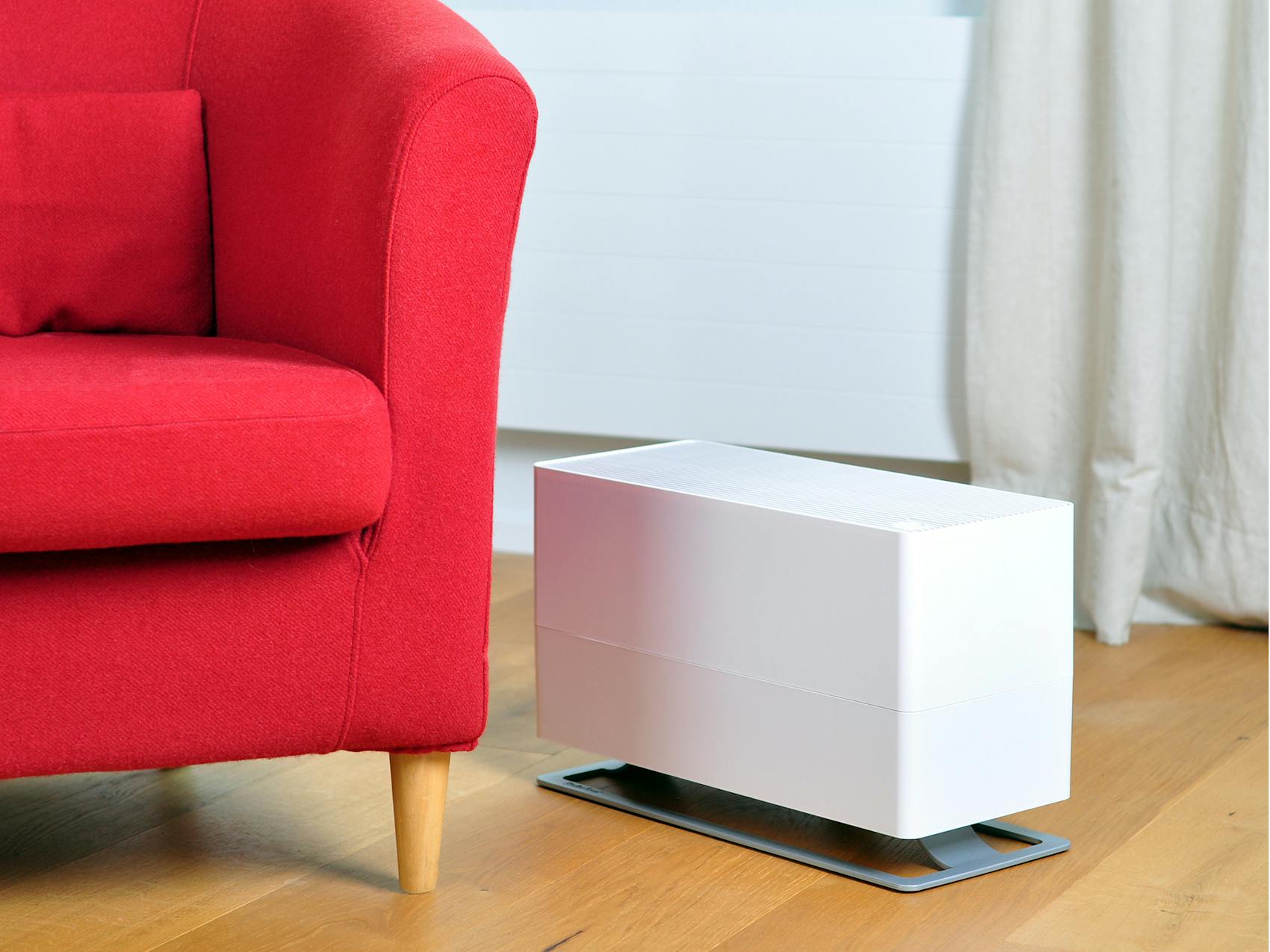 Oskar big humidifier by Stadler Form in white next to a red armchair 
