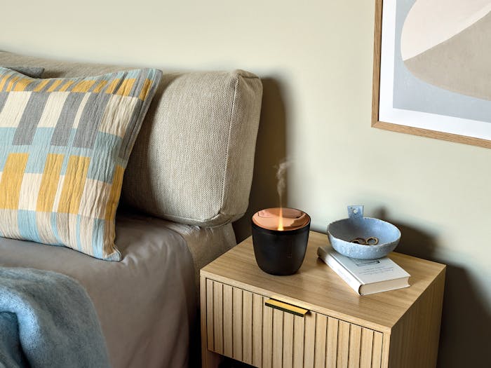 Zoe mobile aroma diffuser in black on a bedside table